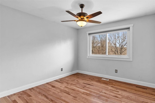 spare room with visible vents, baseboards, light wood-style floors, and a ceiling fan