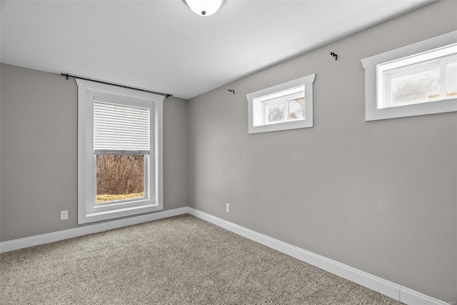 carpeted empty room featuring baseboards