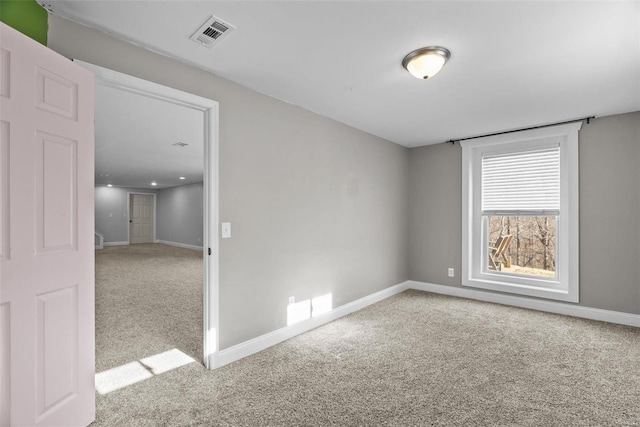 spare room featuring carpet flooring, baseboards, and visible vents