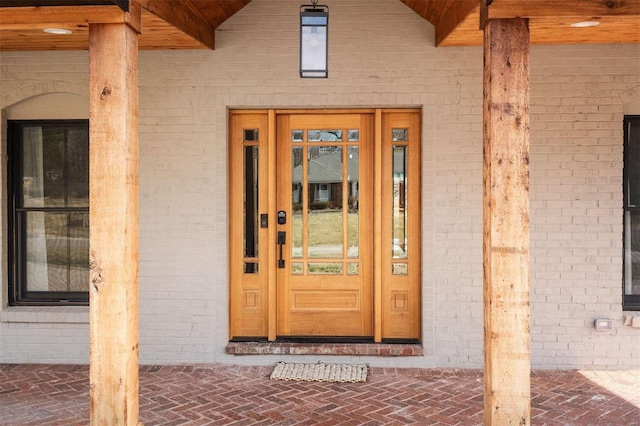 view of exterior entry with brick siding