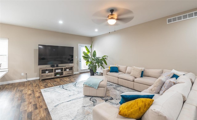 living area with dark wood finished floors, visible vents, plenty of natural light, and baseboards