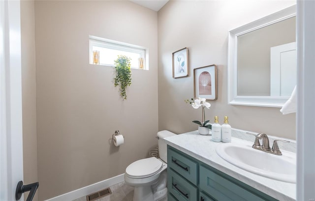 half bathroom featuring toilet, vanity, visible vents, and baseboards