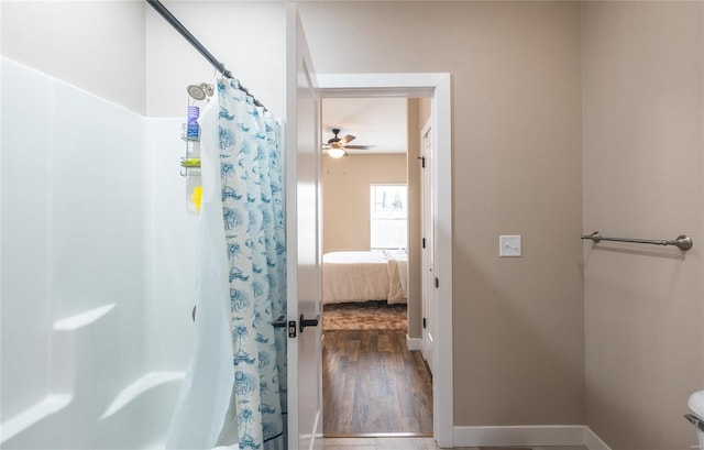 ensuite bathroom featuring baseboards, a shower with curtain, ensuite bath, ceiling fan, and wood finished floors