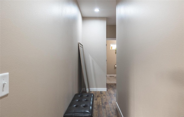 hallway featuring dark wood-style flooring and baseboards