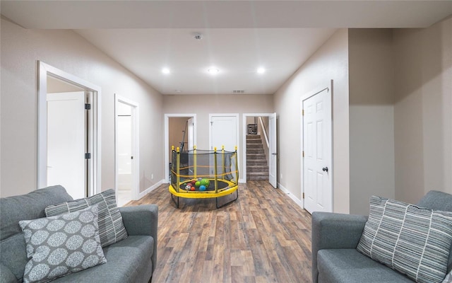 living room with baseboards, visible vents, stairway, and wood finished floors