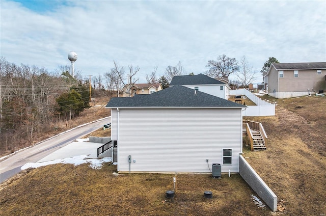 back of property featuring stairs, central AC unit, and a residential view