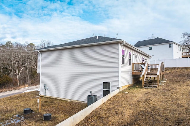 view of side of home with a deck, cooling unit, fence, and stairway