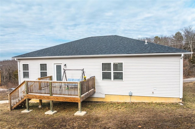 back of house with roof with shingles, a yard, and a wooden deck