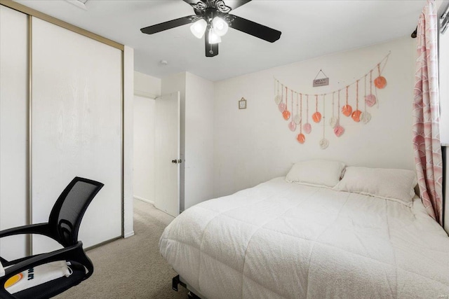 bedroom with a ceiling fan, a closet, and light carpet