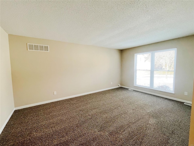 carpeted empty room with a textured ceiling