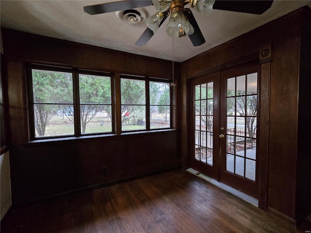 unfurnished sunroom with ceiling fan and french doors