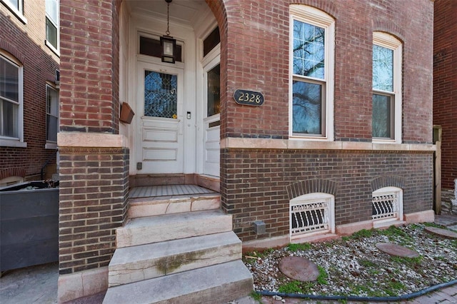 doorway to property with brick siding