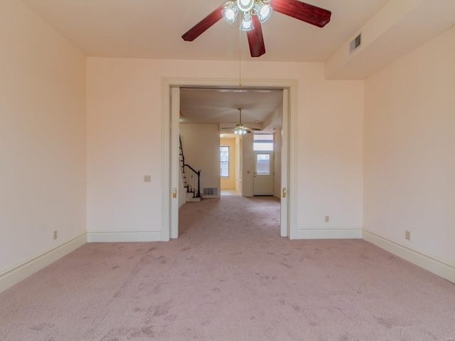 spare room with visible vents, light carpet, baseboards, and stairs