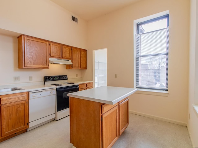 kitchen with a center island, light countertops, electric range, white dishwasher, and under cabinet range hood