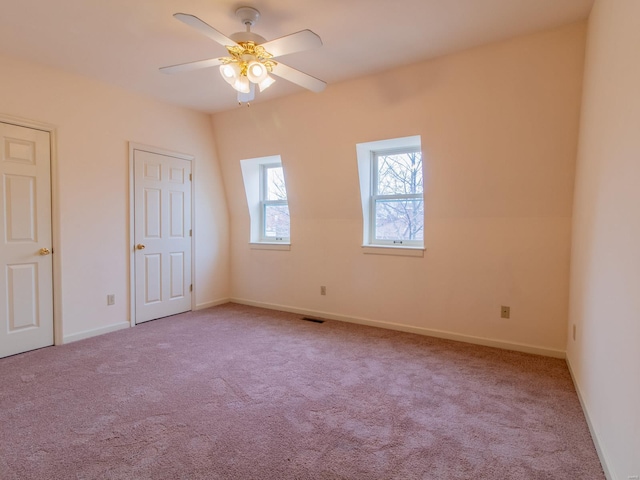 unfurnished bedroom with light carpet, baseboards, visible vents, and a ceiling fan