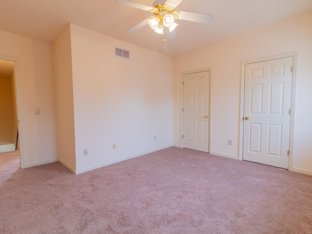 unfurnished room with light carpet, ceiling fan, visible vents, and baseboards