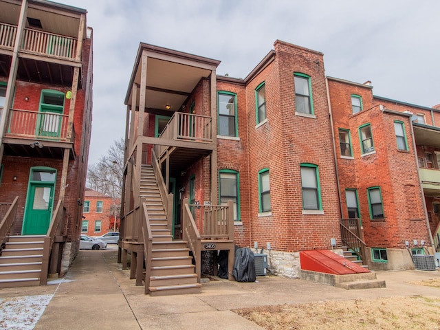 view of property featuring entry steps, stairway, and central AC unit