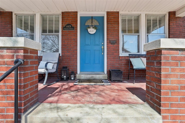 entrance to property featuring brick siding