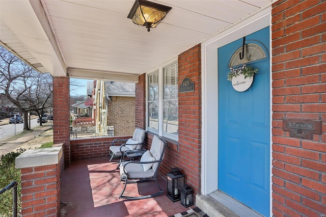 entrance to property with brick siding and covered porch