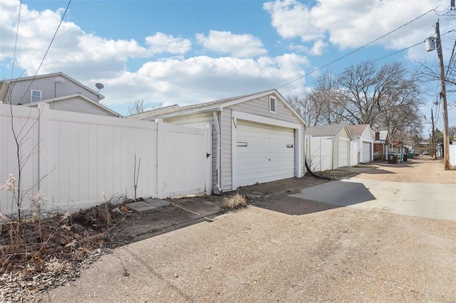 detached garage featuring fence