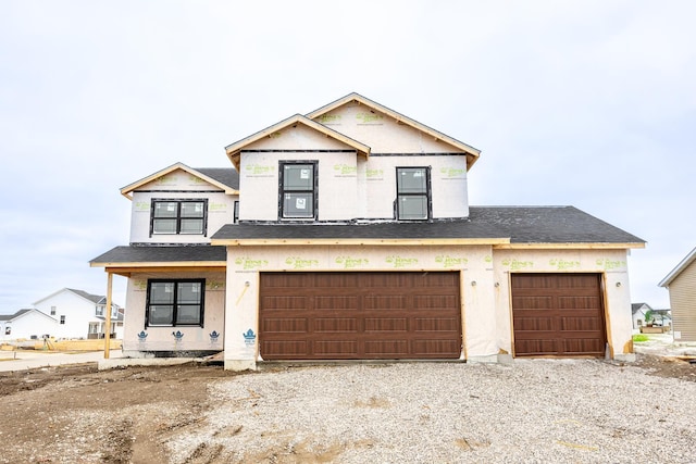 unfinished property featuring a garage, driveway, and roof with shingles