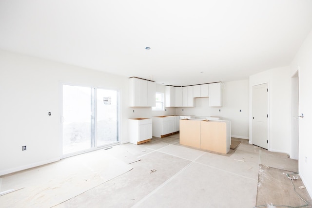 kitchen featuring white cabinets and baseboards