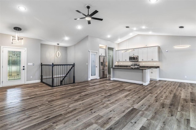 kitchen featuring hardwood / wood-style floors, decorative light fixtures, white cabinetry, lofted ceiling, and stainless steel appliances