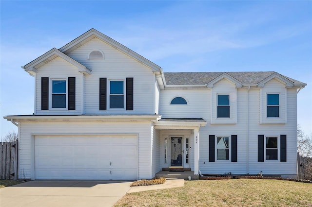 traditional home featuring a front lawn, fence, roof with shingles, a garage, and driveway