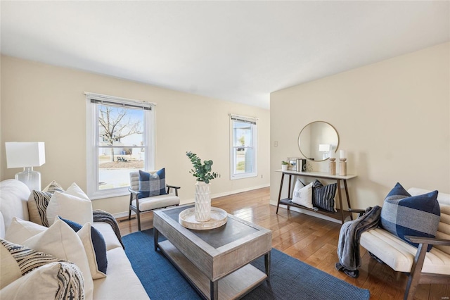 living area with plenty of natural light, baseboards, and hardwood / wood-style flooring