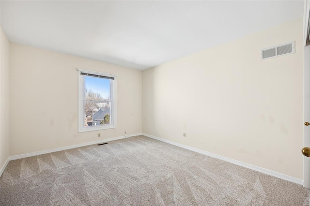 spare room with visible vents, baseboards, and light colored carpet