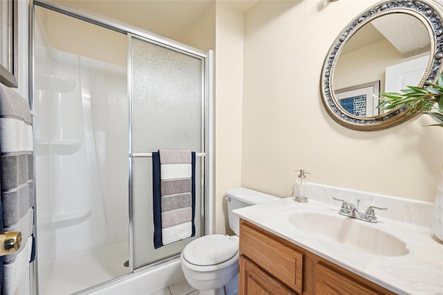 bathroom with a stall shower, toilet, and vanity