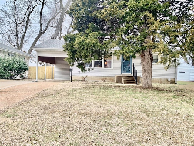 view of property hidden behind natural elements with a front lawn and a carport