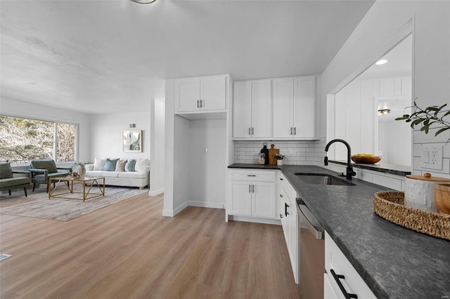 kitchen with white cabinetry, light wood-style flooring, a sink, dishwasher, and tasteful backsplash