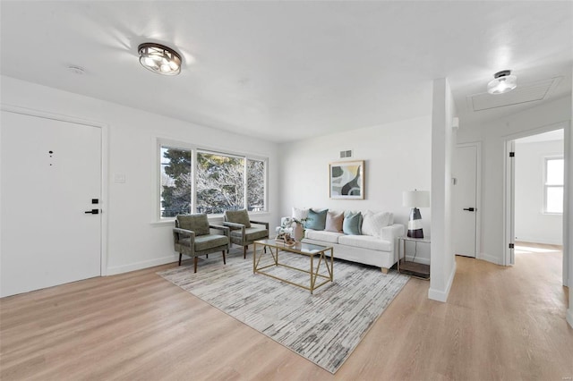 living room featuring light wood-style flooring, baseboards, and visible vents