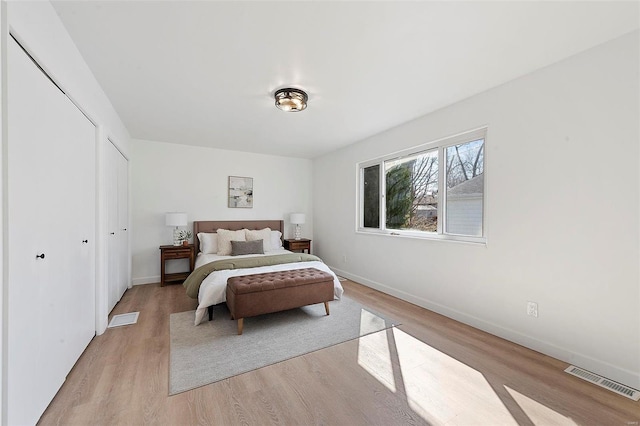 bedroom featuring light wood-style flooring, baseboards, and visible vents