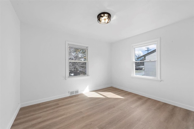 unfurnished room featuring visible vents, baseboards, and light wood-style flooring