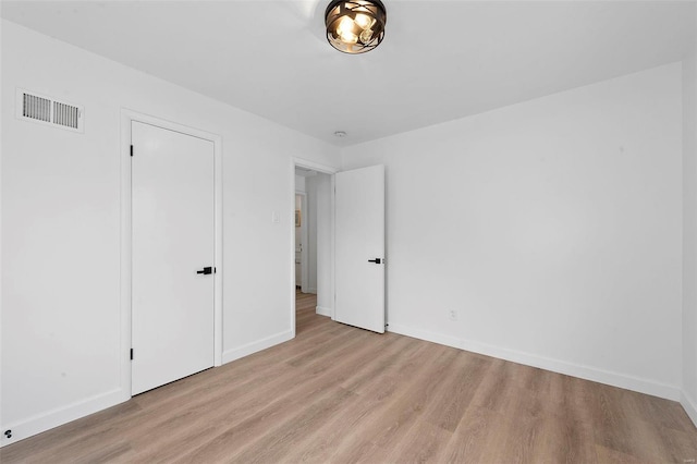 unfurnished bedroom with baseboards, visible vents, and light wood finished floors