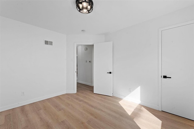 spare room with visible vents, baseboards, and light wood-style floors