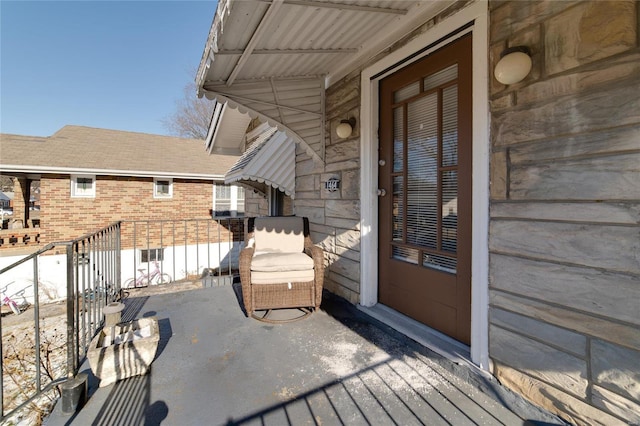 exterior space featuring a balcony and brick siding