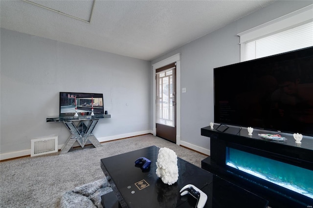 carpeted living area featuring baseboards, visible vents, and a textured ceiling
