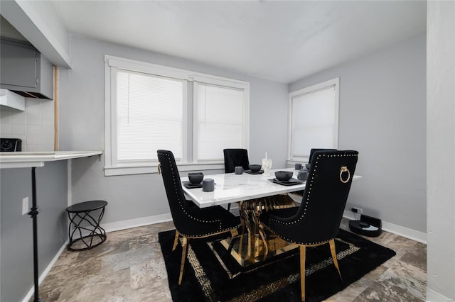 dining area featuring stone finish floor and baseboards