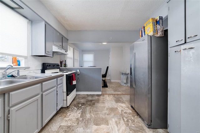 kitchen with under cabinet range hood, a sink, light countertops, stainless steel fridge with ice dispenser, and white range with electric cooktop