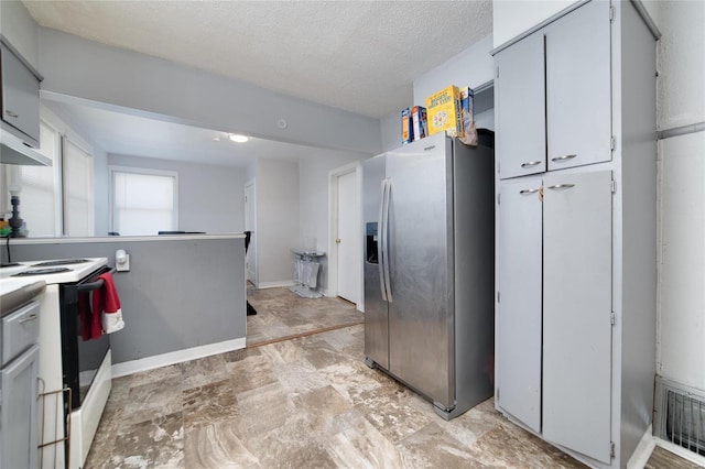 kitchen featuring stainless steel refrigerator with ice dispenser, visible vents, a textured ceiling, range with electric cooktop, and baseboards