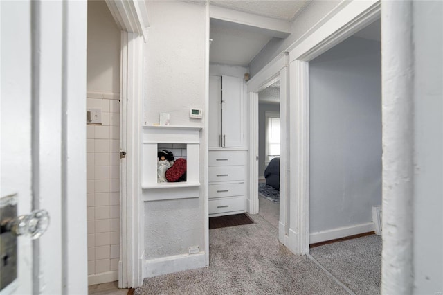 bathroom featuring baseboards and tile walls