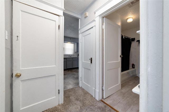 corridor with a textured ceiling and visible vents