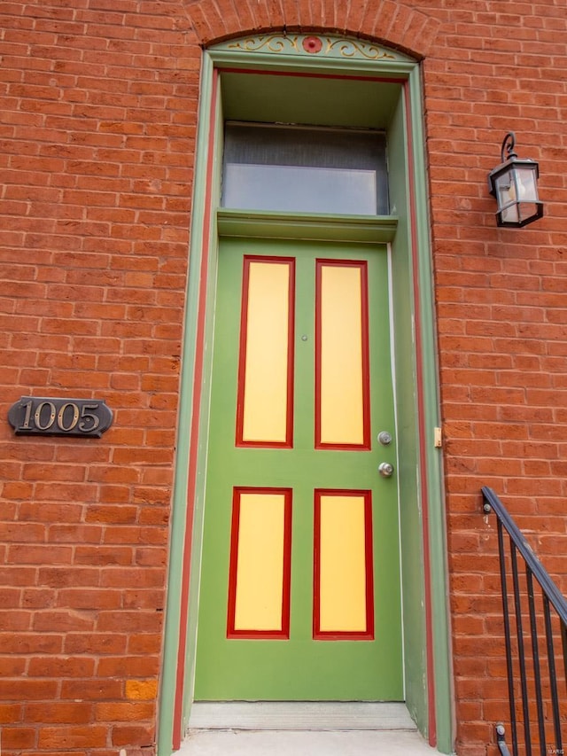 view of exterior entry featuring brick siding