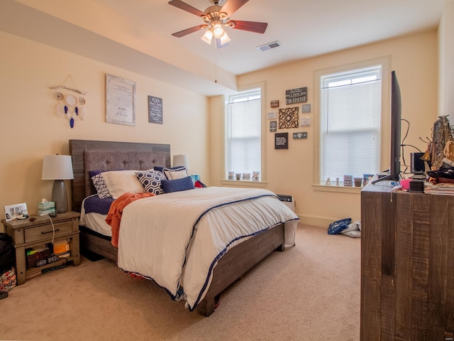 bedroom featuring baseboards, visible vents, light colored carpet, and a ceiling fan