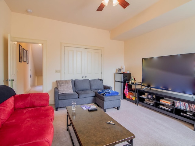 living area featuring light carpet and a ceiling fan