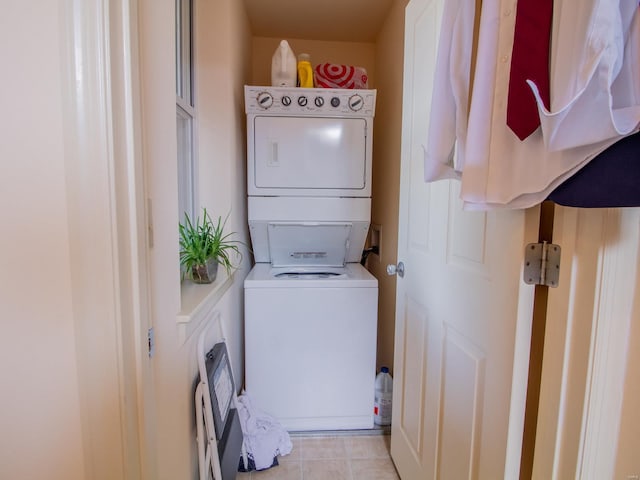 washroom featuring stacked washing maching and dryer and light tile patterned floors