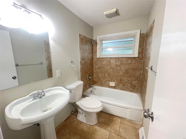 bathroom featuring toilet,  shower combination, a sink, and tile patterned floors